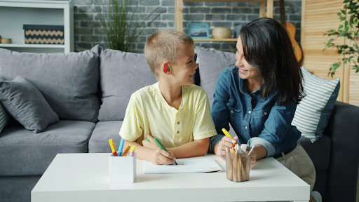 son and mom working at table